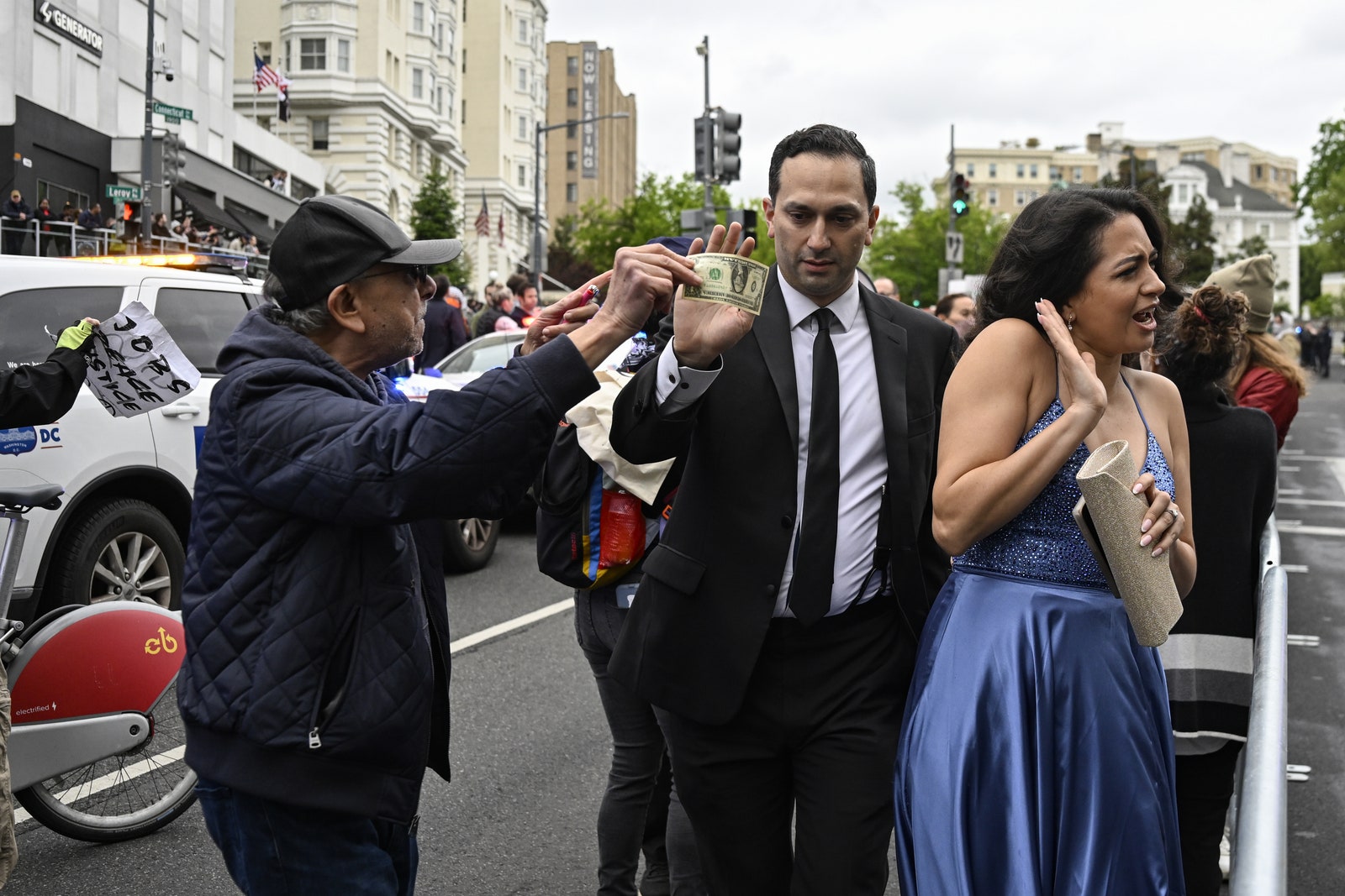 L'image peut contenir des vêtements, des gants, des accessoires, des vêtements de cérémonie, une cravate, un chapeau, une personne adulte, un feu de circulation et une voiture.