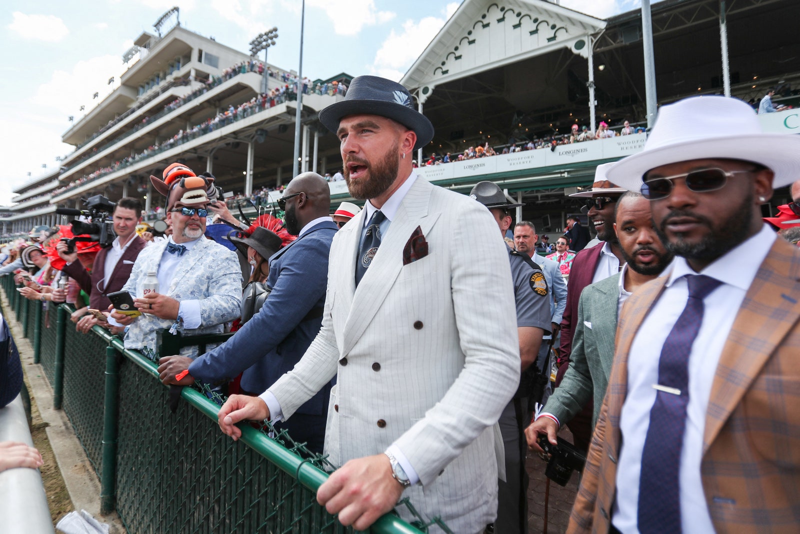 L'image contient peut-être Travis Kelce Personnes Personne Vêtements Chapeau Accessoires Vêtements de cérémonie Cravate Lunettes Adulte et foule