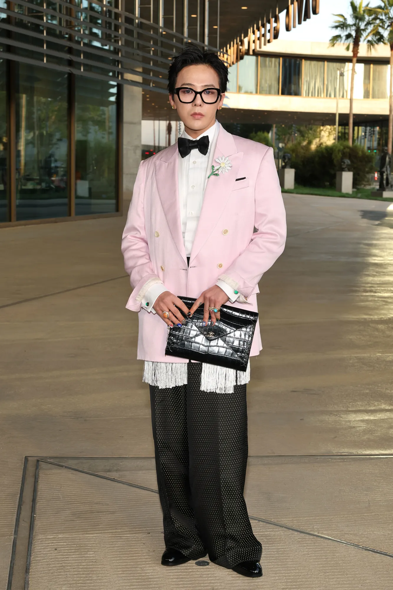 L'image peut contenir des vêtements GDragon, tenue formelle, costume, blazer, manteau, veste, smoking, personne adulte et debout.