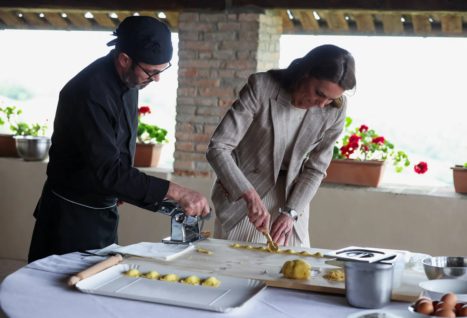 L'image peut contenir une personne adulte, une lame, une arme, un couteau, du pain, des aliments, des vêtements de cuisine, un chapeau et une planche à découper.