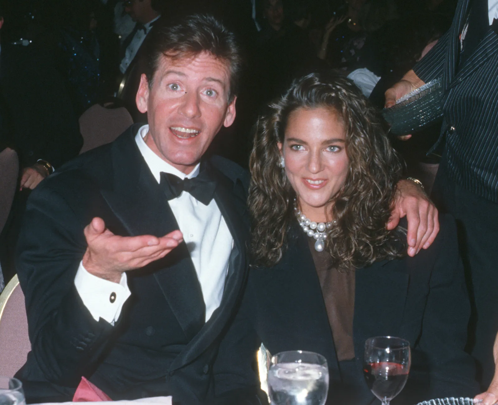 L'image peut contenir des vêtements Calvin Klein, tenue de soirée, costume, visage, tête, personne, photographie, portrait, smoking et blazer.