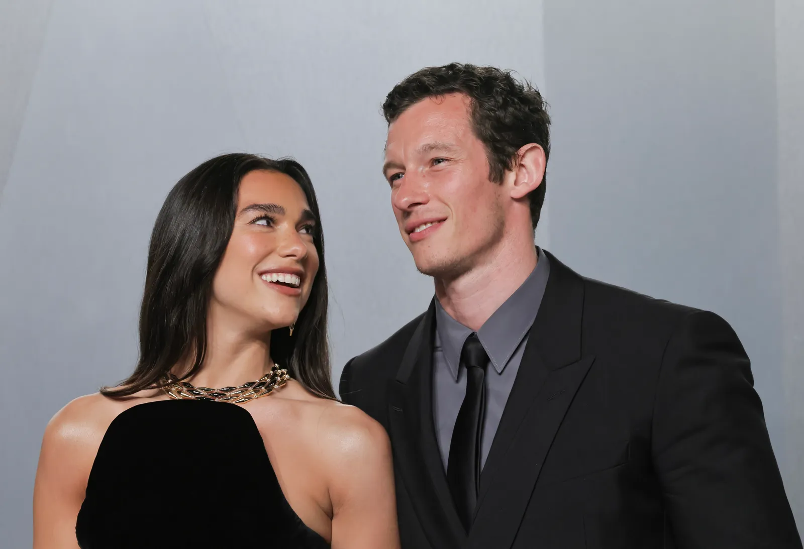 L'image peut contenir Callum Turner Dua Lipa Vêtements Tenue de soirée Costume Visage Tête heureuse Personne Sourire et Adulte