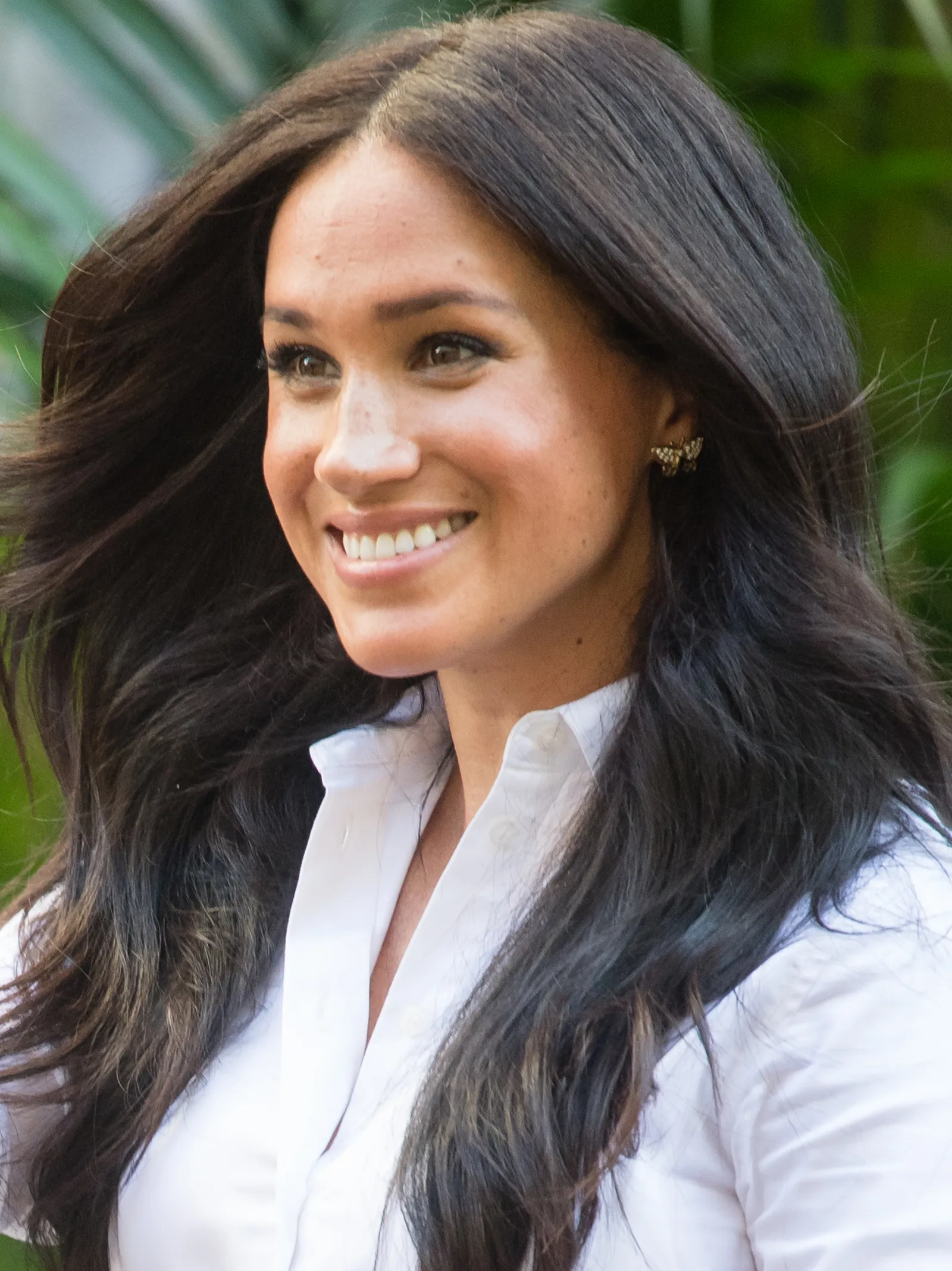 L'image peut contenir Meghan, duchesse de Sussex, tête de personne, visage, fossettes, sourire heureux, partie du corps, cou, adulte et vêtements.