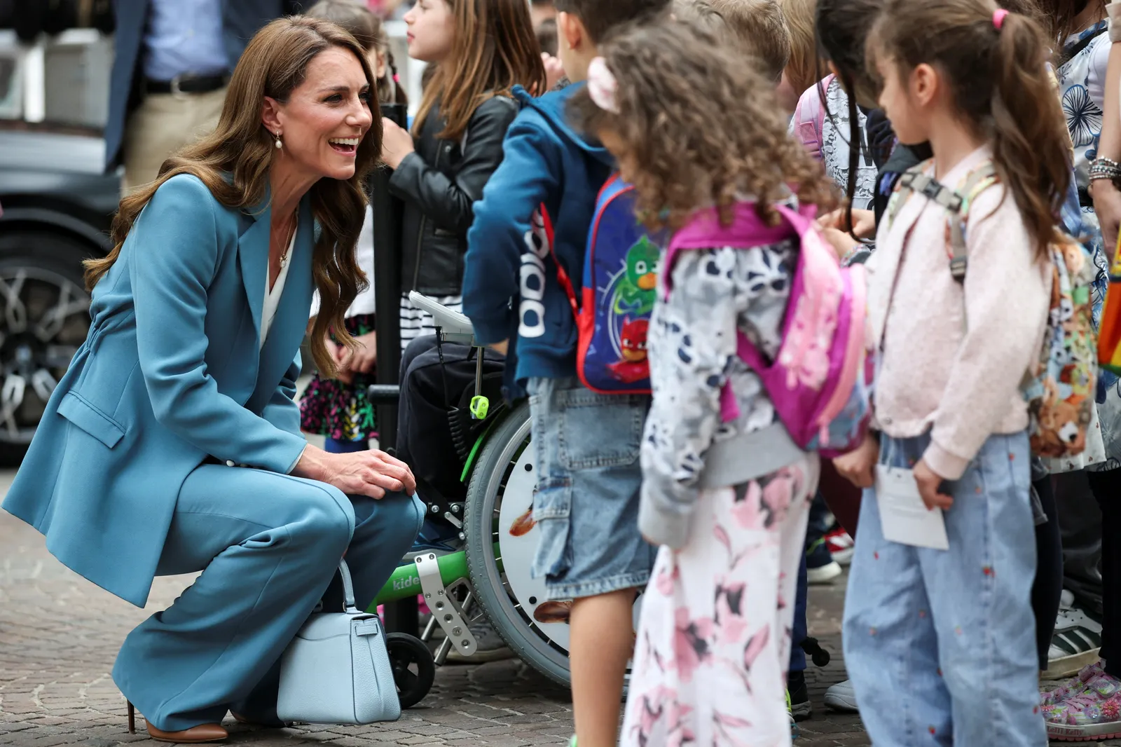 L'image peut contenir des meubles Chaise Enfant Personne Adulte Accessoires Bijoux Collier Fauteuil roulant Vêtements et shorts