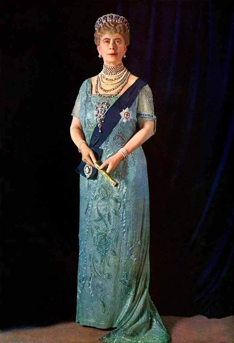 Un portrait royal officiel de la reine Mary de Teck pris en 1935. Une femme plus âgée portant une robe turquoise, une ceinture bleue et un diadème en diamant.