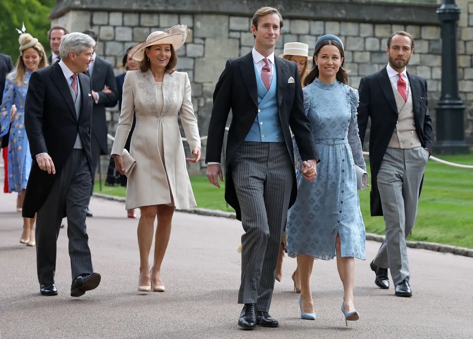 Les membres de la famille Middleton se promènent dehors en route vers une cérémonie de mariage. Ils sont habillés formellement...