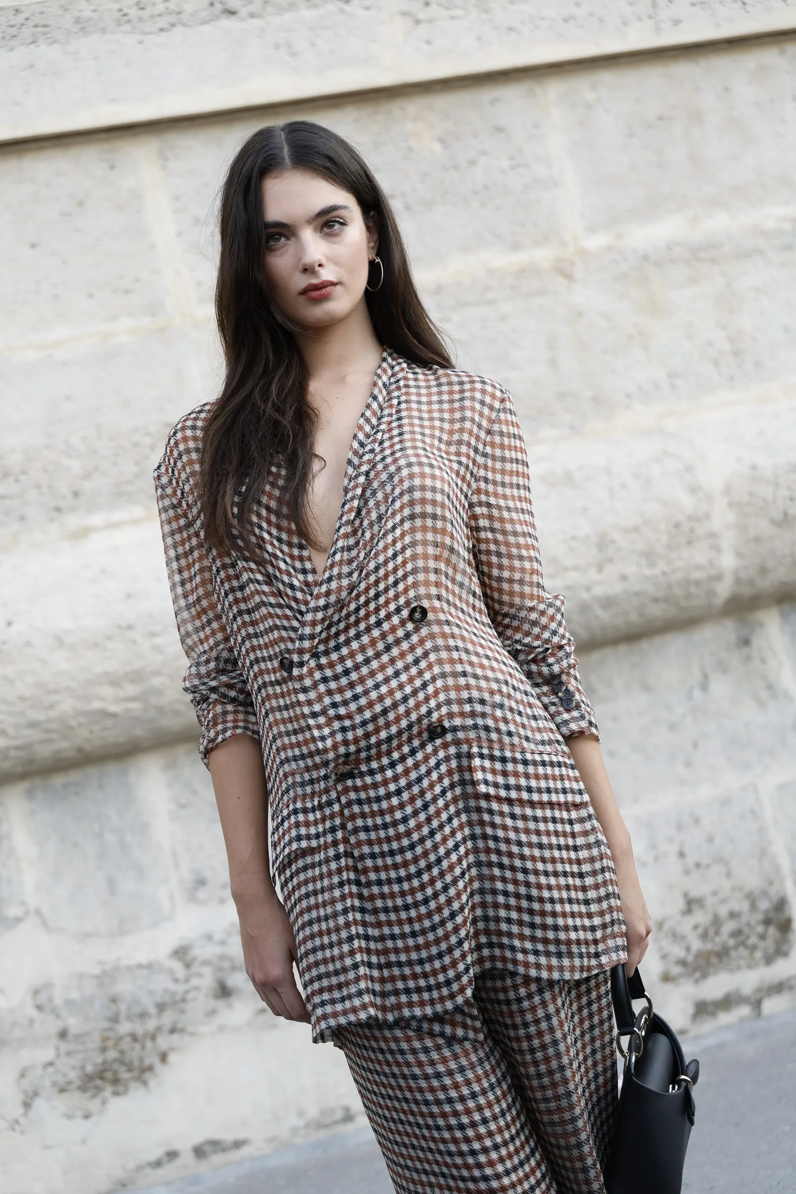 L'image peut contenir des manches de vêtements Cheveux noirs Personne Adulte Vêtements de cérémonie Manteau Accessoires Sac Sac à main et tête